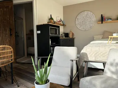 a bedroom with a bed and a table and chairs at Hello Noordwijk - Studio Pietheinplein 1 in Noordwijk aan Zee