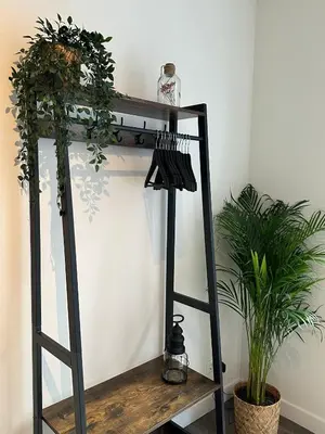 a black ladder shelf with plants on it at Hello Noordwijk - Studio Pietheinplein 1 in Noordwijk aan Zee