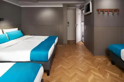 a hotel room with two beds and a tv at Stanley Collection Hotel Hegra Amsterdam in Amsterdam