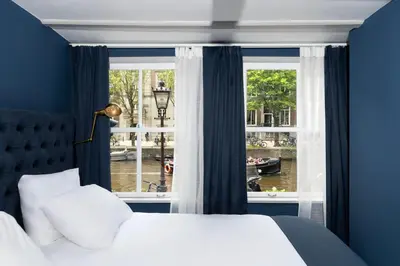 a bedroom with a bed and a large window at Stanley Collection Hotel Hegra Amsterdam in Amsterdam