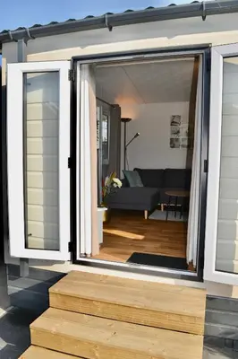 a sliding glass door on a house with a living room at Chalet 27 in Zandvoort