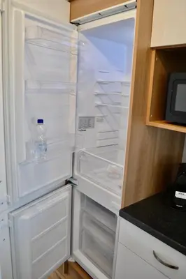 an empty refrigerator with a bottle of water in it at Chalet 27 in Zandvoort