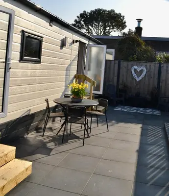 a patio with a table and chairs on a patio at Chalet 27 in Zandvoort