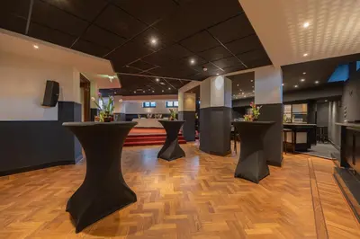 a lobby with black stools on a wooden floor at Grand Hotel Amrâth Amsterdam in Amsterdam