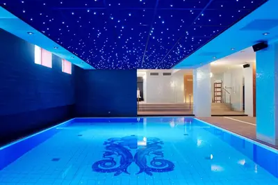 a swimming pool with blue lights on the ceiling at Grand Hotel Amrâth Amsterdam in Amsterdam