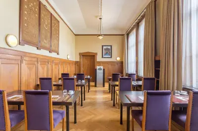 a restaurant with tables and chairs in a room at Grand Hotel Amrâth Amsterdam in Amsterdam