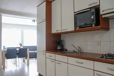 a kitchen with a sink and a microwave at Zeezand in Egmond aan Zee