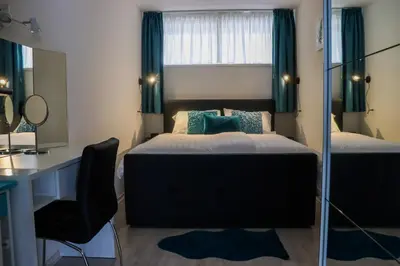 a bedroom with a bed and a desk and a mirror at Zeezand in Egmond aan Zee