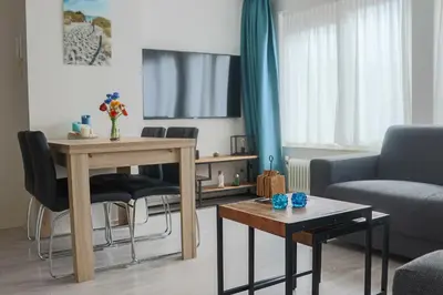 a living room with a table and chairs at Zeezand in Egmond aan Zee