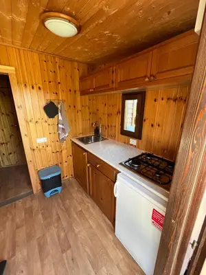 a kitchen with a stove and a sink in a cabin at De Fuut in Nieuwe-Niedorp
