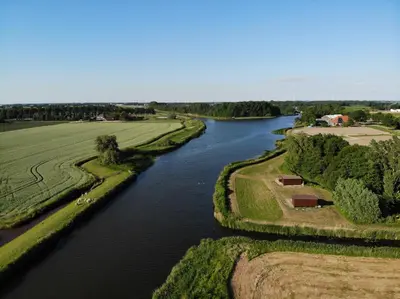 an aerial view of a river with trees and fields at De Fuut in Nieuwe-Niedorp