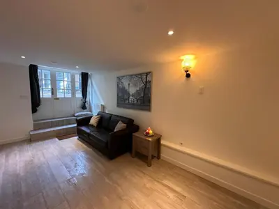 a living room with a black couch and a table at Tulip House Luxury Apartment - Top Location - Rijksmuseum - Leidseplein AMSTERDAM Central 120 m2 ALL Private with kitchen in Amsterdam