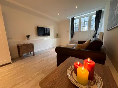 a living room with a couch and two candles on a table at Tulip House Luxury Apartment - Top Location - Rijksmuseum - Leidseplein AMSTERDAM Central 120 m2 ALL Private with kitchen in Amsterdam