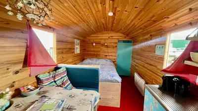 a small room with a bed in a wooden cabin at Island Sleeping in Aalsmeer
