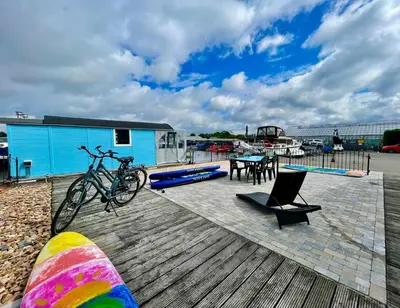 a bike parked on a wooden deck with a table and chairs at Island Sleeping in Aalsmeer