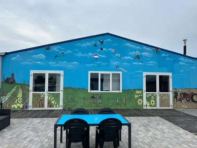a blue building with a mural on the side of it at Island Sleeping in Aalsmeer