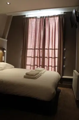 a bedroom with a bed and a window with towels on it at Blossoms City Hotel in Amsterdam