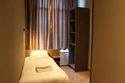 a small bedroom with a bed and a window at Blossoms City Hotel in Amsterdam
