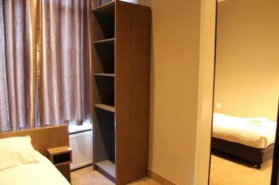 a bedroom with a book shelf next to a bed at Blossoms City Hotel in Amsterdam