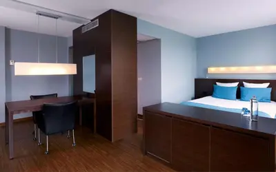 a bedroom with a bed and a desk and a bed and a table at Park Plaza Amsterdam Airport in Lijnden