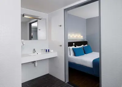 a bathroom with a bed and a sink and a mirror at Park Plaza Amsterdam Airport in Lijnden