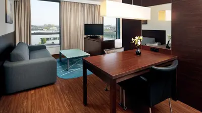 a hotel room with a desk and a couch and a chair at Park Plaza Amsterdam Airport in Lijnden