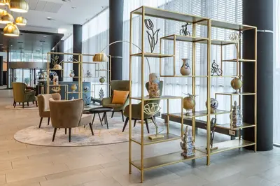 a room with chairs and tables and vases on shelves at Park Plaza Amsterdam Airport in Lijnden