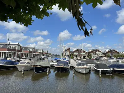 a bunch of boats docked in a marina with houses at Apartment Westergeest-1 by Interhome in Uitgeest