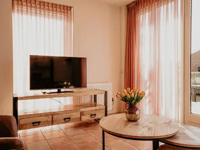a living room with a television and a coffee table at Apartment Westergeest-1 by Interhome in Uitgeest