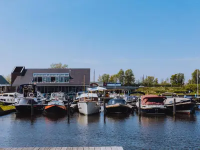 a group of boats docked in the water near a building at Apartment Oostergeest by Interhome in Uitgeest