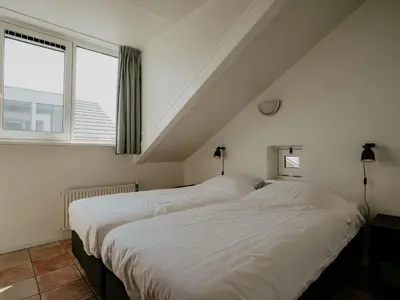 two beds in a room with a window at Apartment Oostergeest by Interhome in Uitgeest