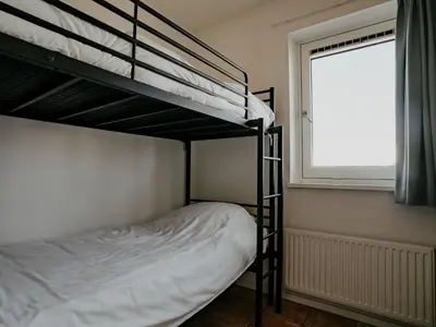 a bedroom with two bunk beds and a window at Apartment Oostergeest by Interhome in Uitgeest