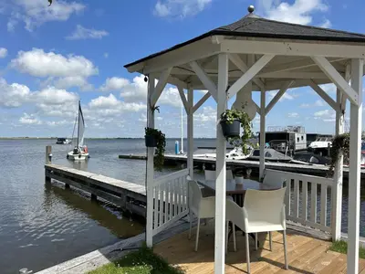 a gazebo with a table and chairs on a dock at Apartment Oostergeest by Interhome in Uitgeest
