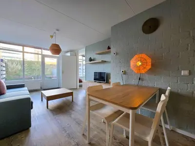 a living room with a wooden table and a couch at Moana 1 in Egmond aan Zee