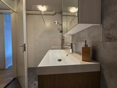 a bathroom with a white sink and a mirror at Moana 1 in Egmond aan Zee