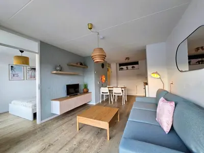 a living room with a blue couch and a table at Moana 1 in Egmond aan Zee
