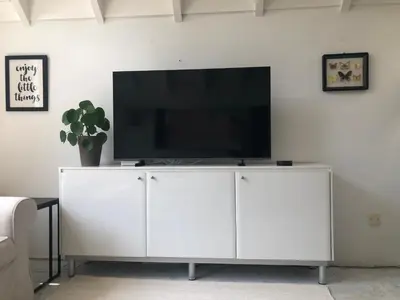a white entertainment center with a flat screen tv on top at Globetrotter in Bergen