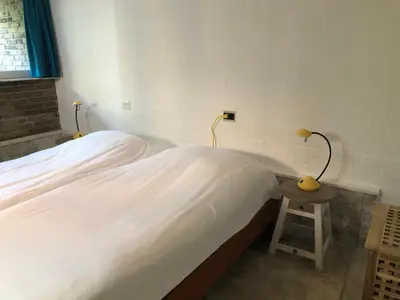 a bedroom with two beds and a table with lamps at Globetrotter in Bergen