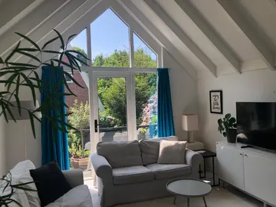 a living room with a couch and a large window at Globetrotter in Bergen