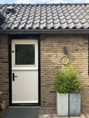 a brick house with a white door and a window at Globetrotter in Bergen