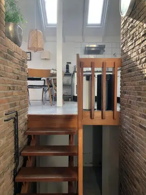 a wooden staircase in a room with a kitchen at Globetrotter in Bergen