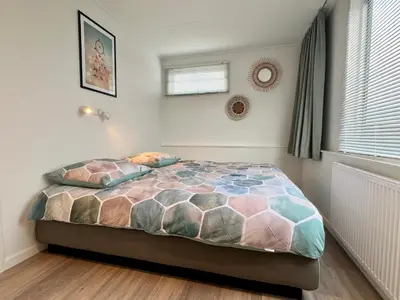 a bedroom with a bed with two pillows on it at New- Private Cosy Houseboat, on a lake near Amsterdam in Vinkeveen
