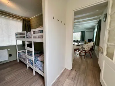 a room with bunk beds and a dining room at New- Private Cosy Houseboat, on a lake near Amsterdam in Vinkeveen