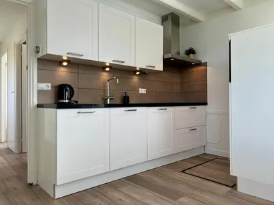 a kitchen with white cabinets and a sink at New- Private Cosy Houseboat, on a lake near Amsterdam in Vinkeveen