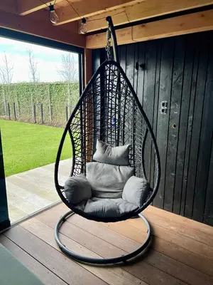 a hanging chair with pillows on a porch at New- Private Cosy Houseboat, on a lake near Amsterdam in Vinkeveen