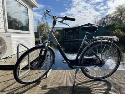 a bike parked on a dock next to a house at New- Private Cosy Houseboat, on a lake near Amsterdam in Vinkeveen