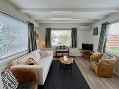 a living room with a white couch and chairs at New- Private Cosy Houseboat, on a lake near Amsterdam in Vinkeveen