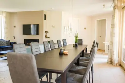 a dining room with a table and chairs at Newly renovated luxurious Villa / hottub / sauna / 7 bedrooms in Zeewolde