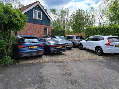 a group of parked cars parked in a driveway at Newly renovated luxurious Villa / hottub / sauna / 7 bedrooms in Zeewolde
