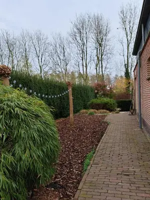 a garden with a brick walkway next to a house at Newly renovated luxurious Villa / hottub / sauna / 7 bedrooms in Zeewolde